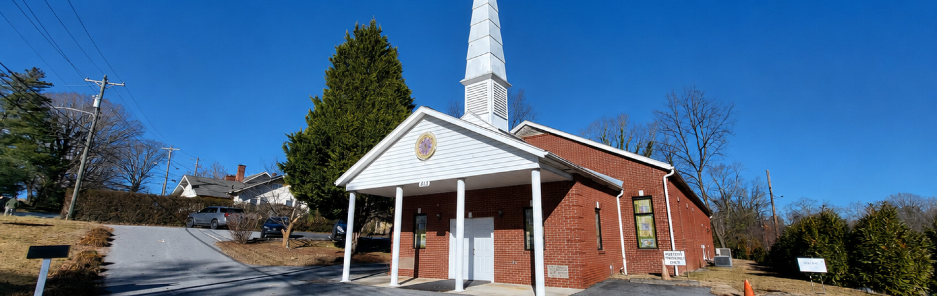 Church with a white steeple, with a blue sky in the background.