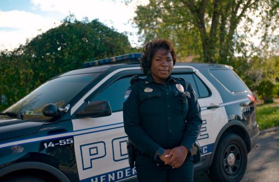 Female officer in front of patrol car