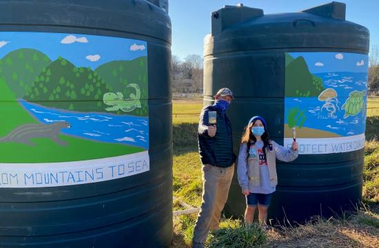 Man and girl with rainwater cisterns
