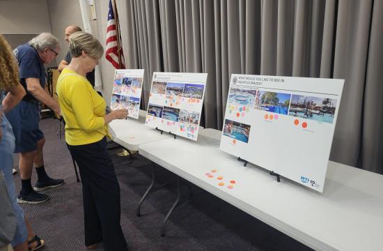 Person voting with dots at a public input meeting