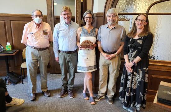 5 people stand with award at a council meeting