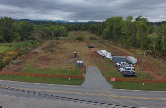 Field beside lower mud creek showing construction supplies and vehicles