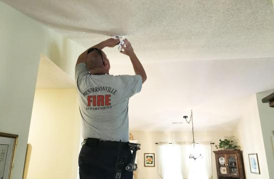 Firefighter installing a smoke alarm