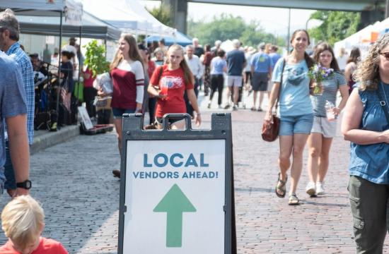 a picture of the Hendersonville Farmers market with a sign that points into the market saying local vendors ahead