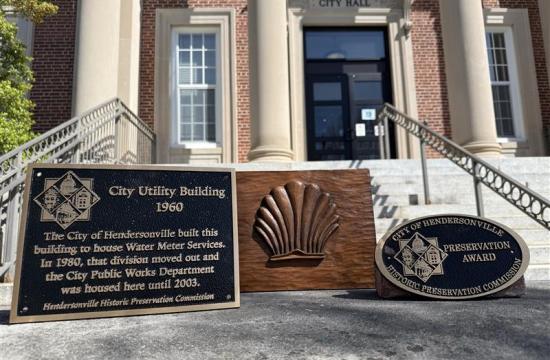A historic plaque, and Historic Preservation Award, are sitting outside at the foot of the steps to City Hall.