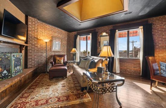 A loft in Downtown Hendersonville, showcasing red brick walls, seating and curtains.