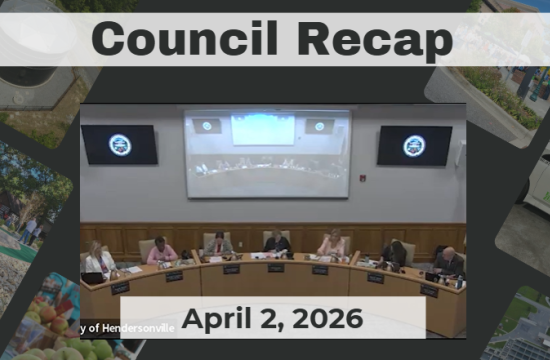 Council members are seated around a dais. 