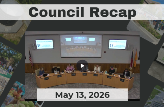 Council members are seated around a dais. 