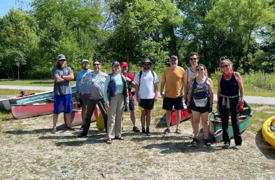 Group of volunteers outside, smiling during a stream cleanup event.
