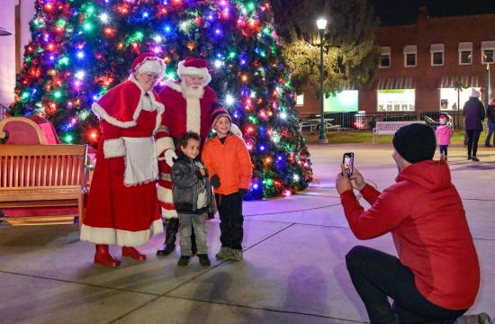 photo of santa and mrs claus in front of tree