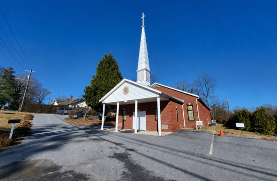 A church with a white steeple, with a clear blue sky in the background.