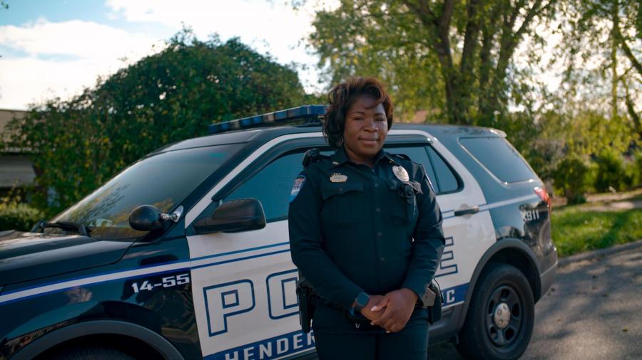 Female officer in front of patrol car