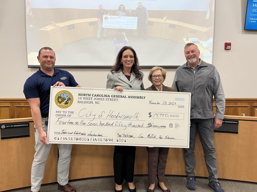 4 people holding a giant check