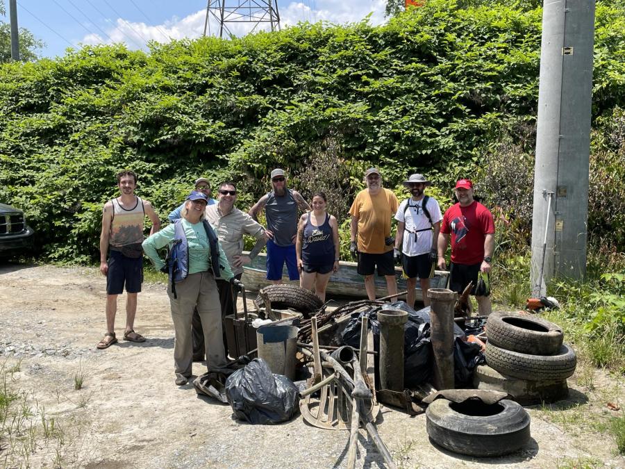 Group of volunteers standing with a pile of tires after a river clean up