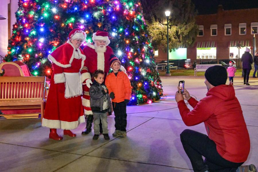 photo of santa and mrs claus in front of tree