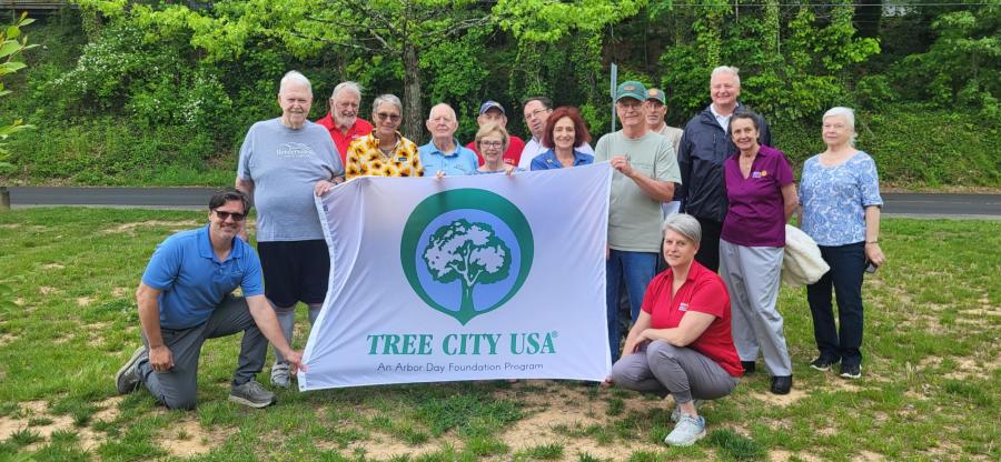 People holding a tree city flag