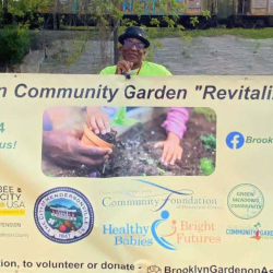 Several community members holding banner of community groups and funders that made the expansion and revitalization efforts possible.