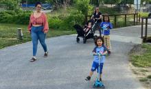 kid on scooter with family