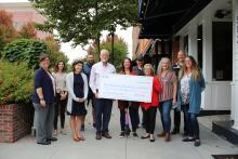 Image of city staff and volunteers with large check from duke energy for $25,000