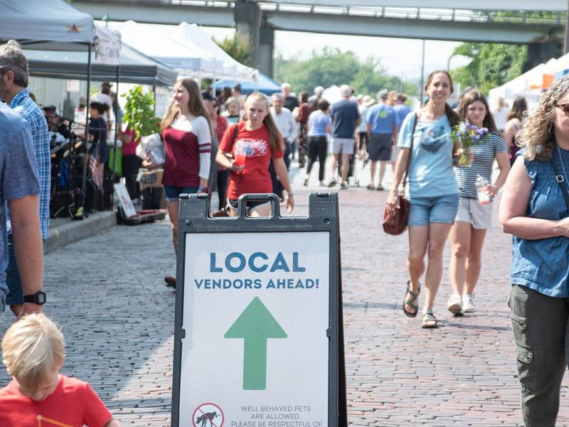 a picture of the Hendersonville Farmers market with a sign that points into the market saying local vendors ahead