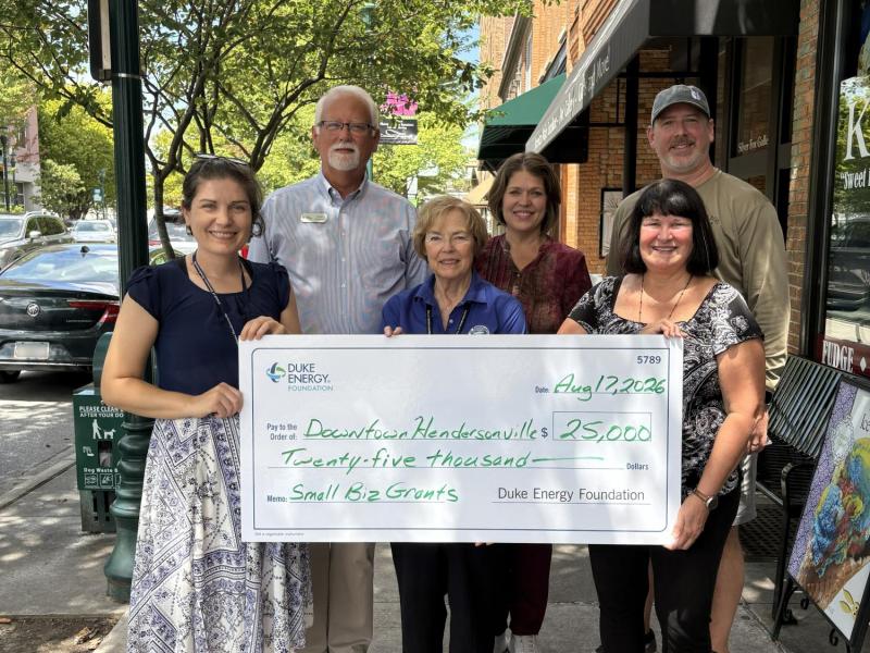 a large check with duke energy foundation and people holding the check