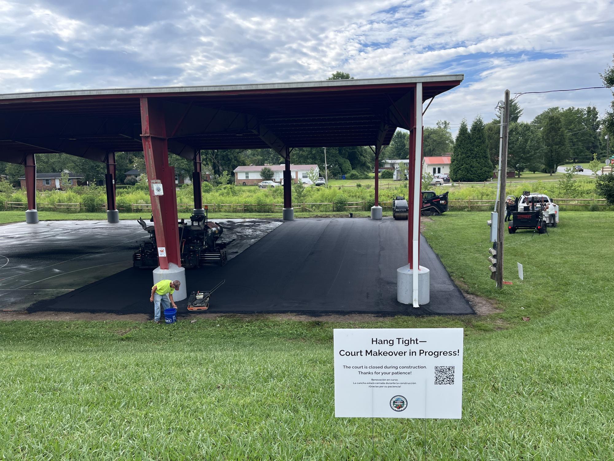 paving equipment resurfacing a covered basketball court
