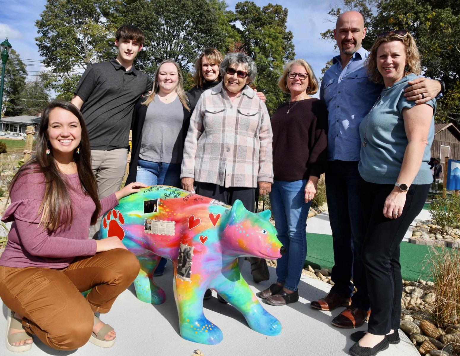 Artist Bethany Joy and members of Laura Corn's family pose next to a bear statue created in her honor