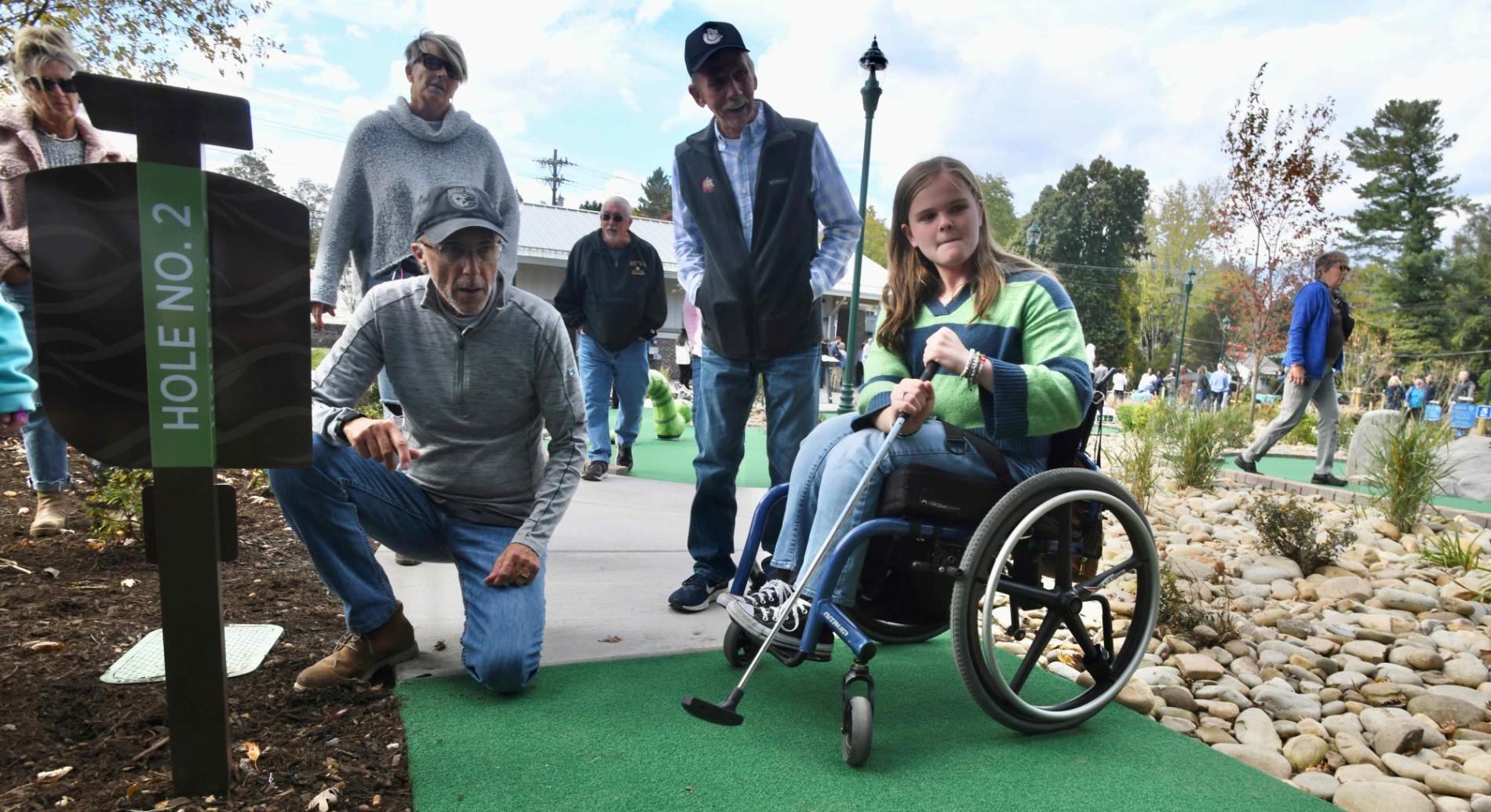 Campbell Hodge playing minigolf in her wheelchair 