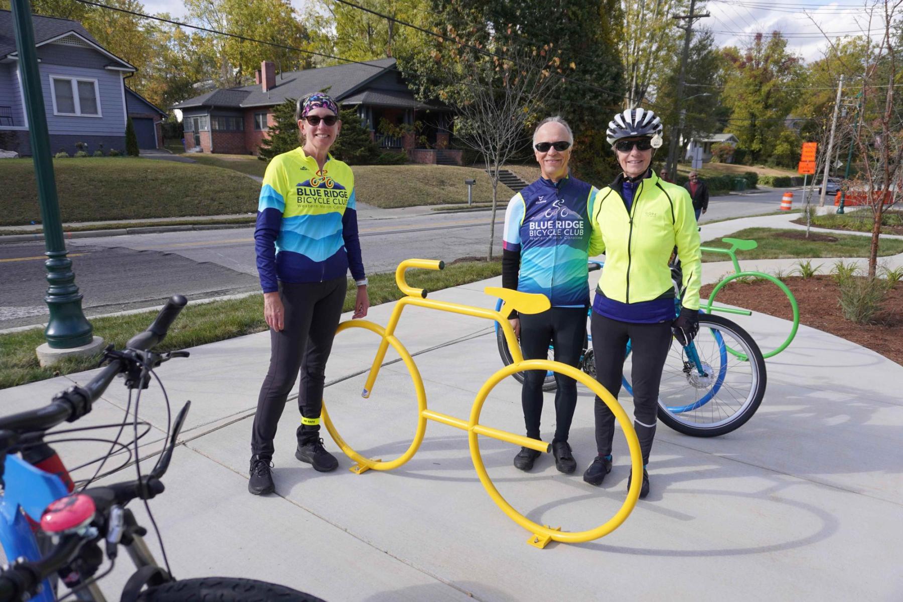 3 people standing next to colorful bike racks made possible by the Blue Ridge Bicycle Club