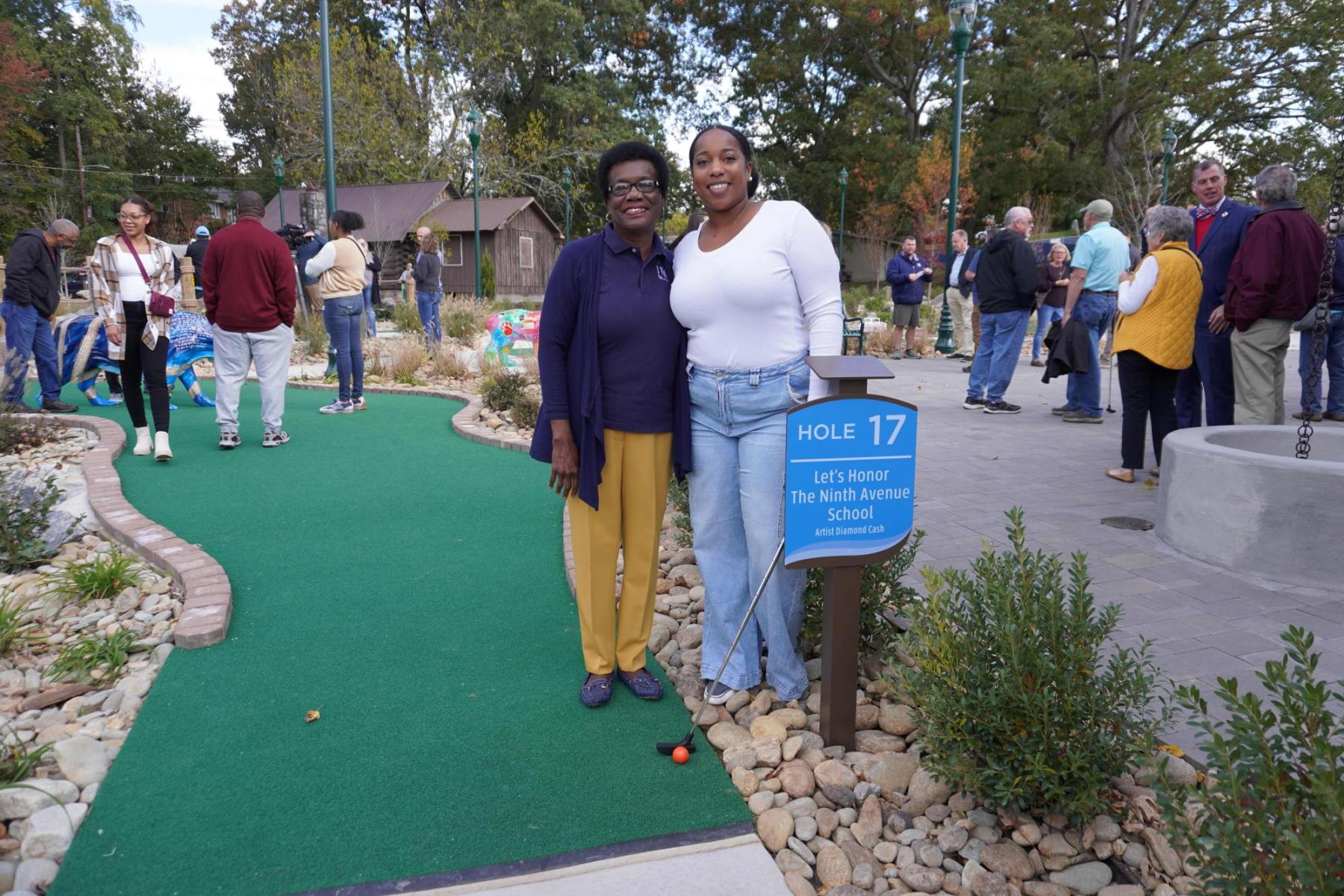 Melinda Lowrance and Diamond Cash stand next to the Ninth Avenue School mini golf green