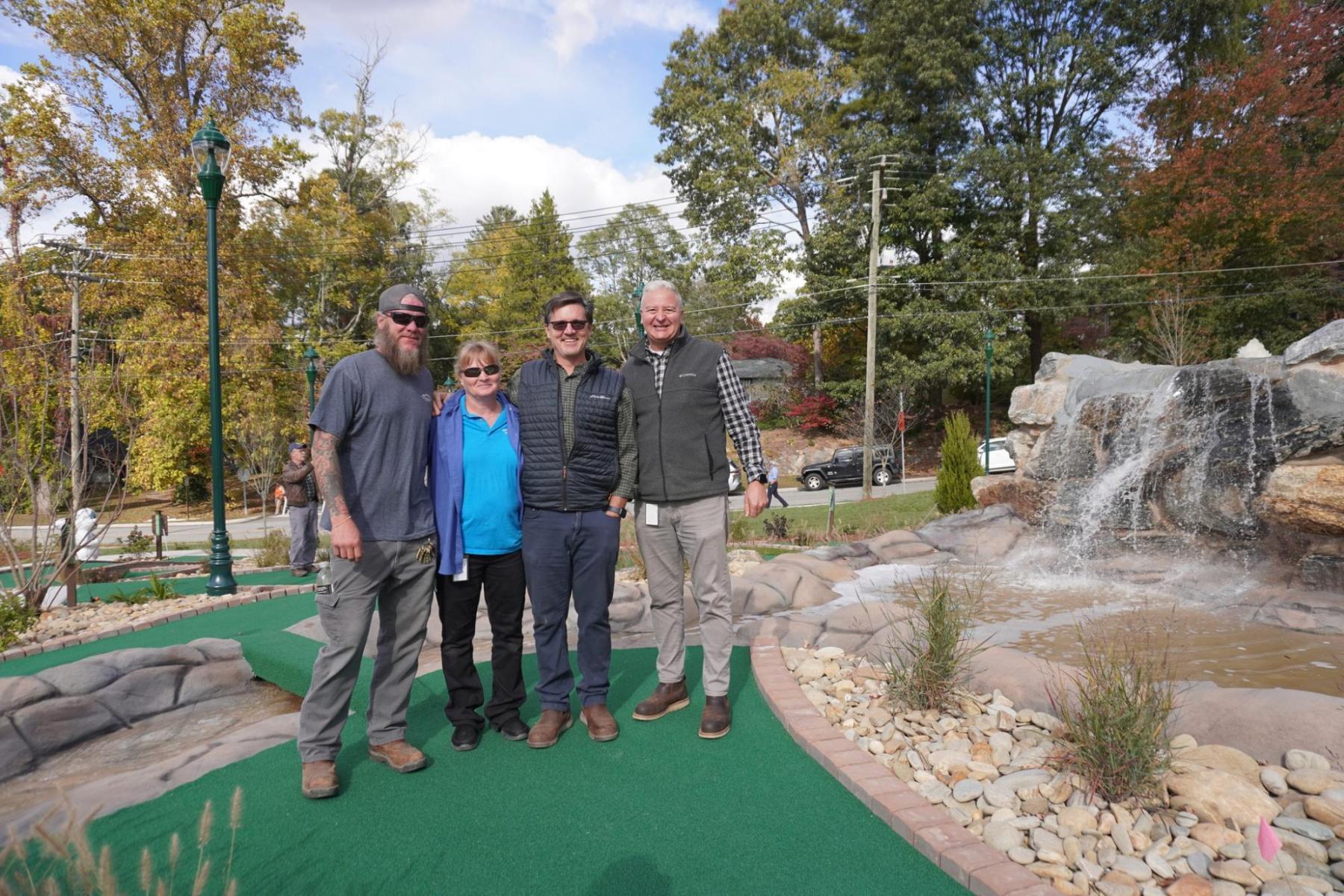 Public Works team members standing in front of the mini golf waterfall