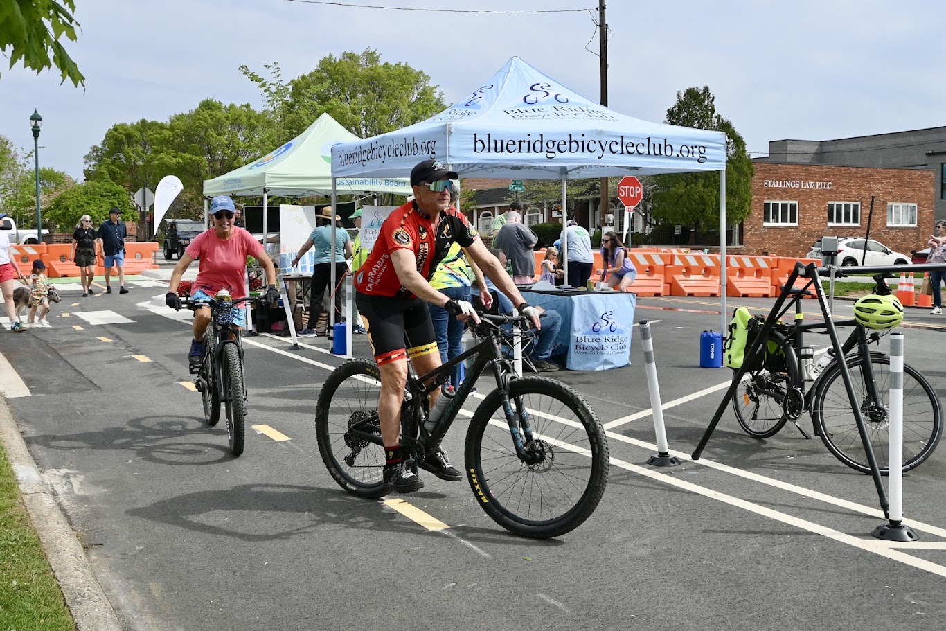 Bikes riding down Main Street, with event tents in the background at Hendo Earth Fest. 