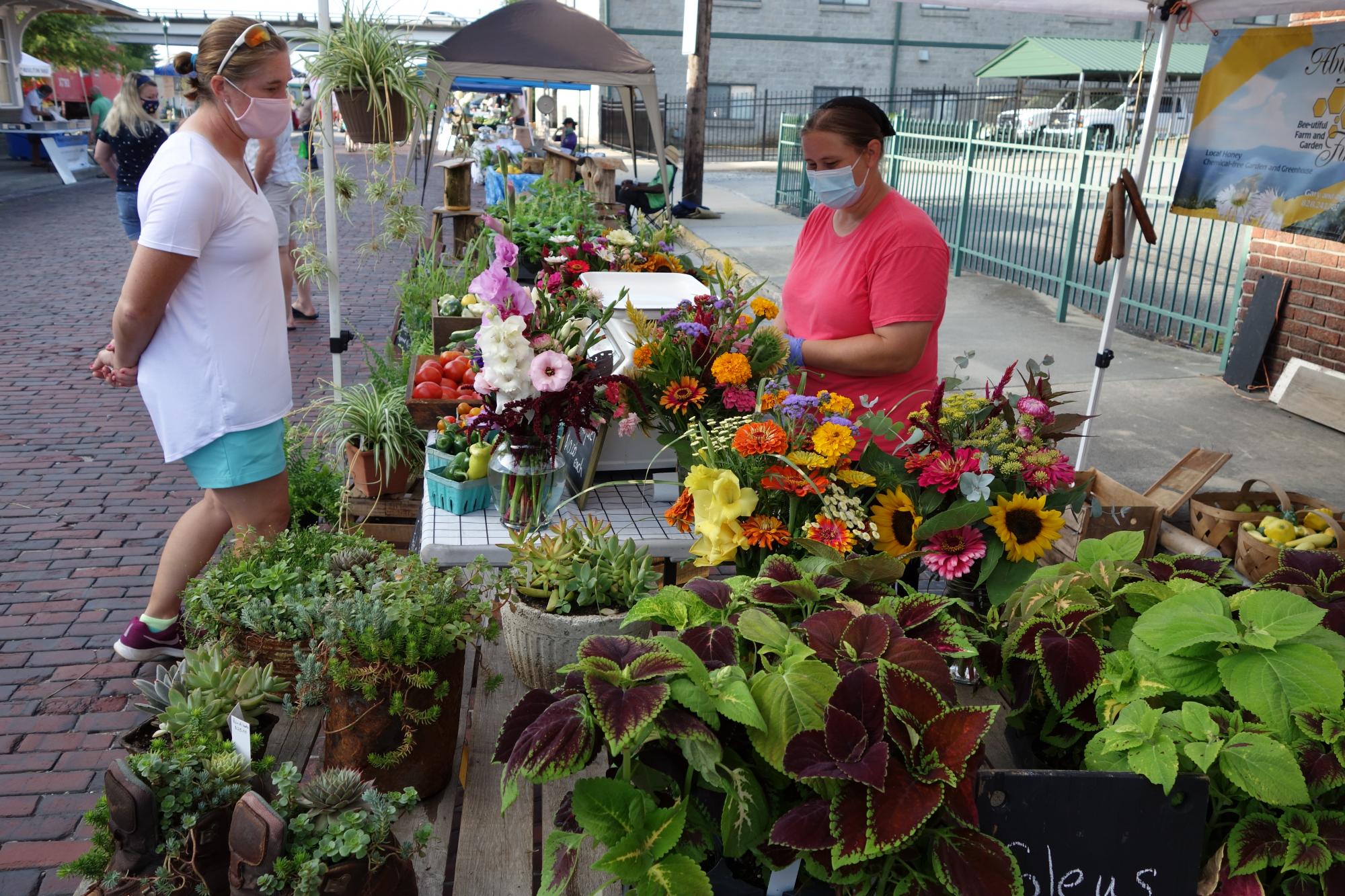 Farmers market vendor selling flowers and plants
