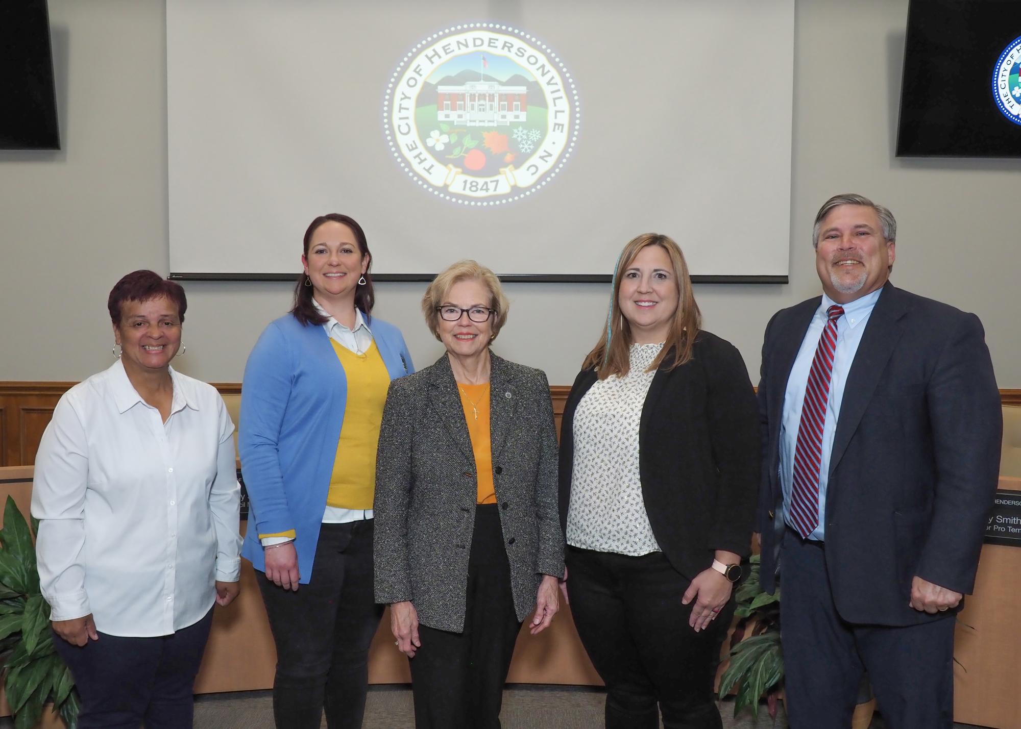 City Council members standing in front of the city seal logo