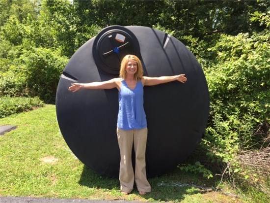 Photo of Cassie Ashworth in front of cistern prior to the cistern being installed at ironwood square