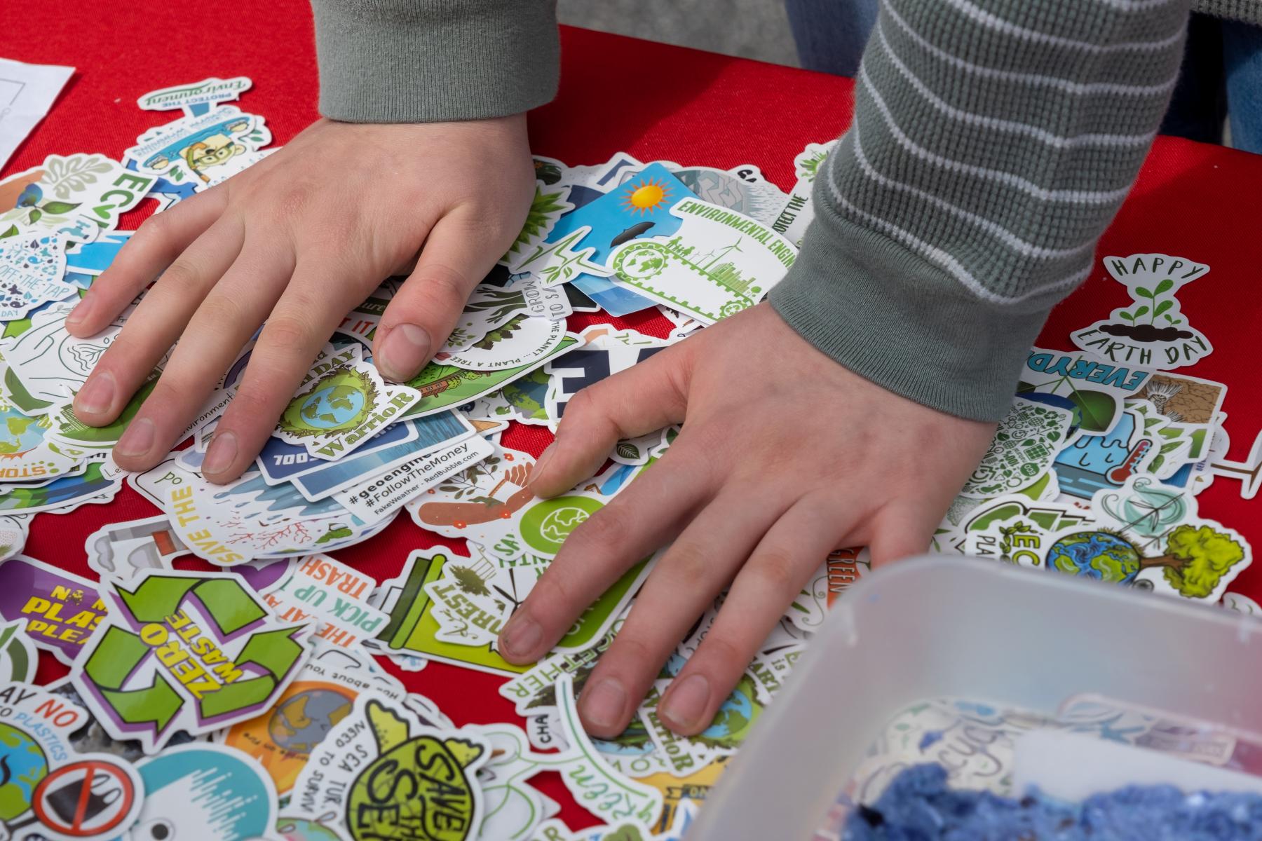 One event participant grabs a sticker to promote the importance of our earth.