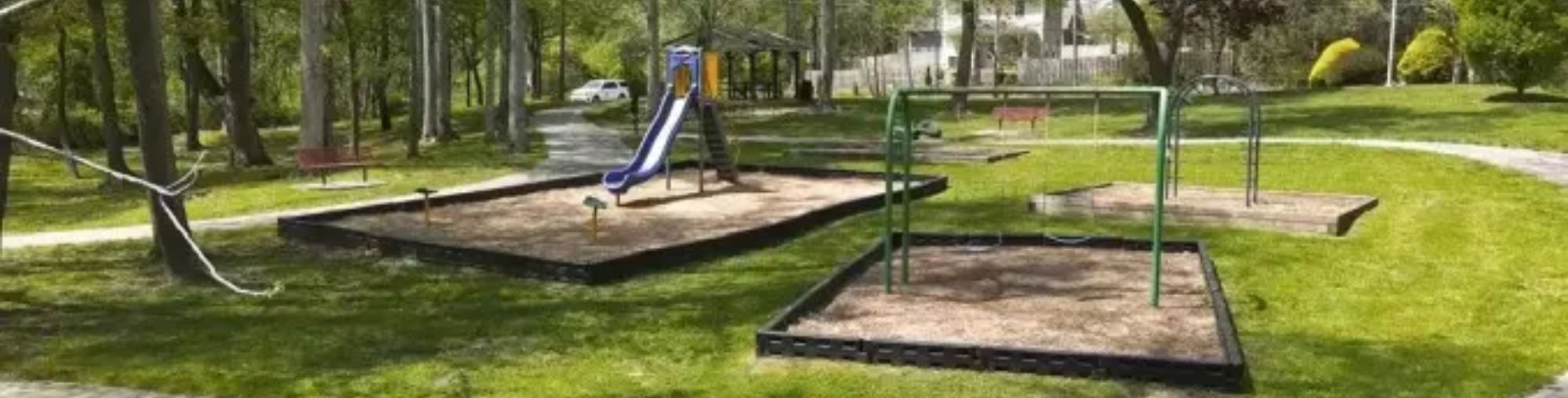 Four Seasons Rotary Park slide and swing set with walking path.