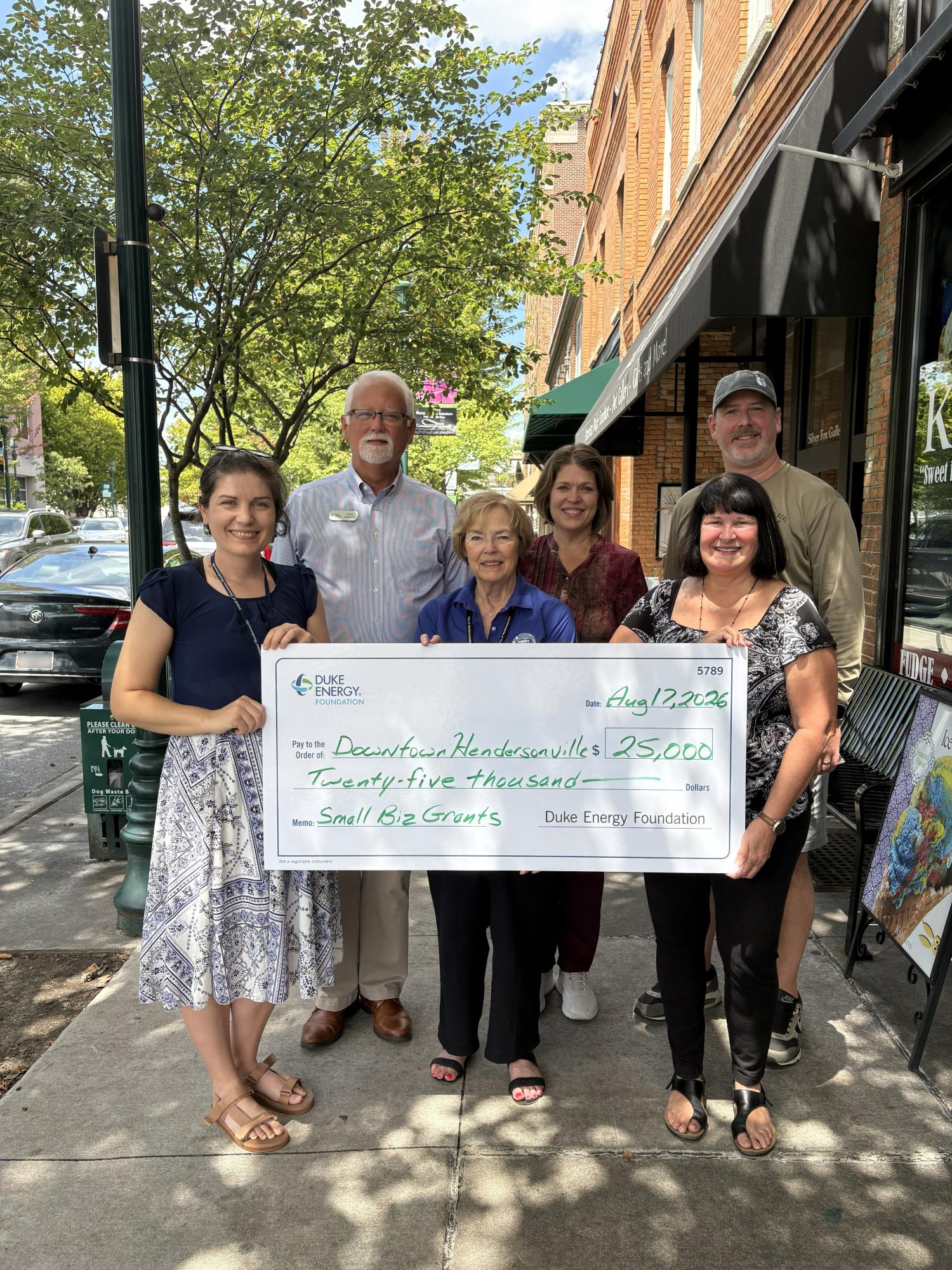 a large check with duke energy foundation and people holding the check